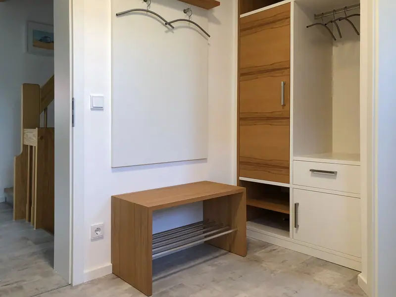 Garderobe mit Holz-Sitzbank mit Schuhrost aus Rundstäben und einem Schrankteil mit offenen Fächern